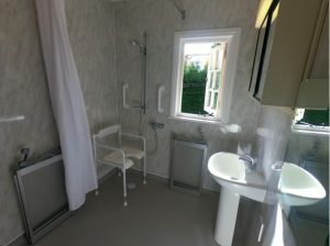 accessible showering area with half height carer screen