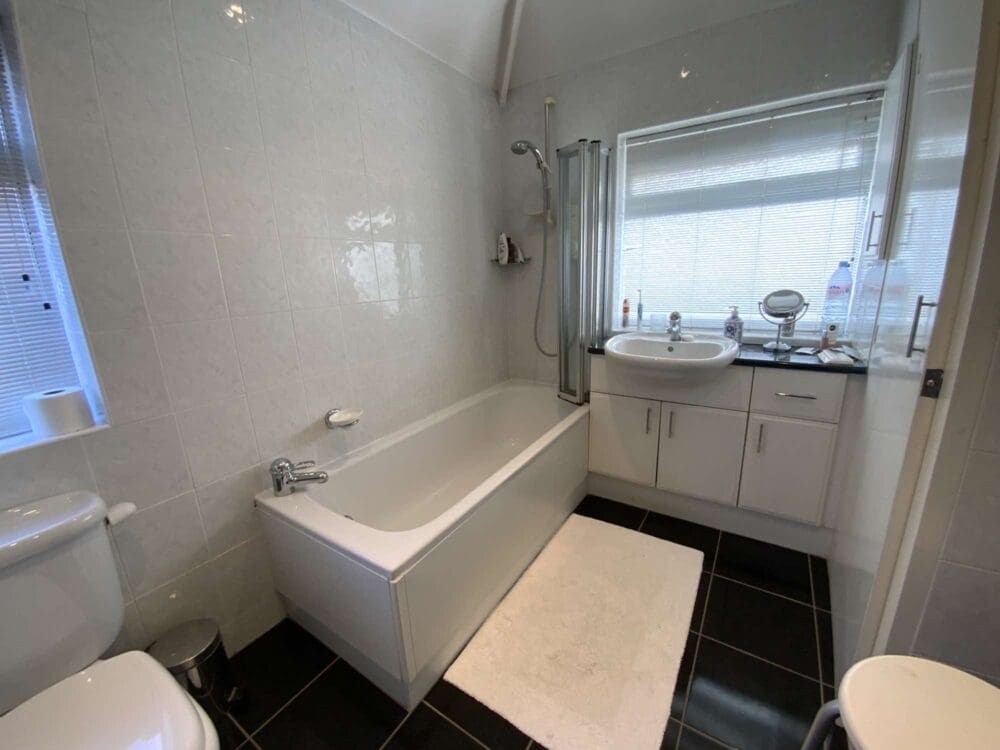 Mrs W bathroom before with tall, non-accessible bath, cramped space and white, plain walls