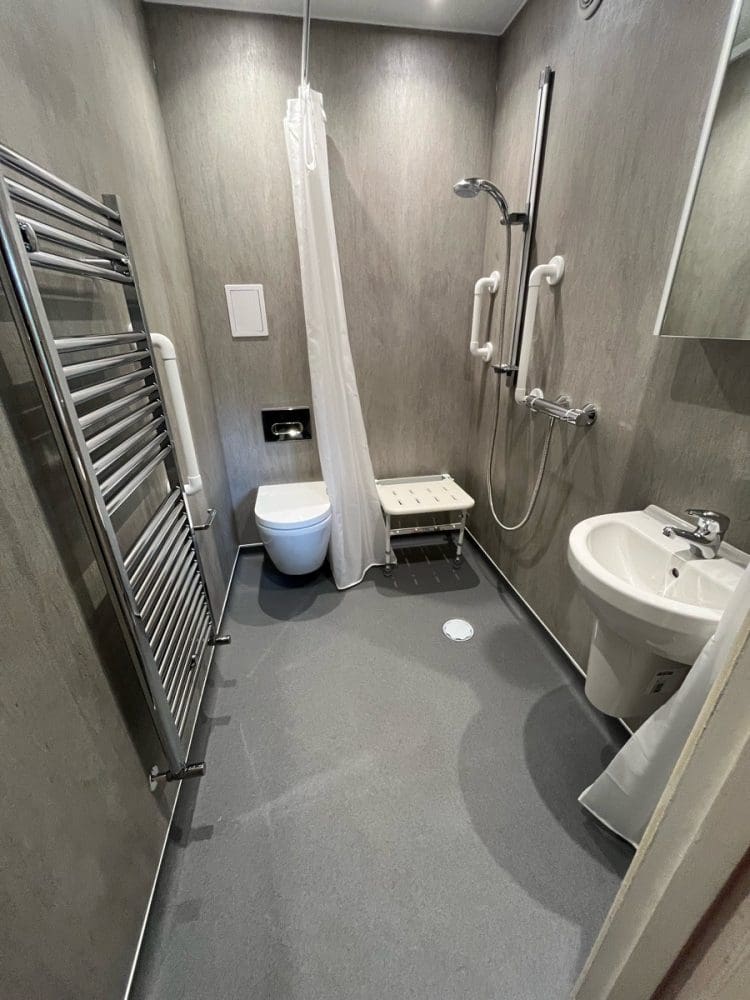 Small Wetroom installation with a wall fixed white folding seat