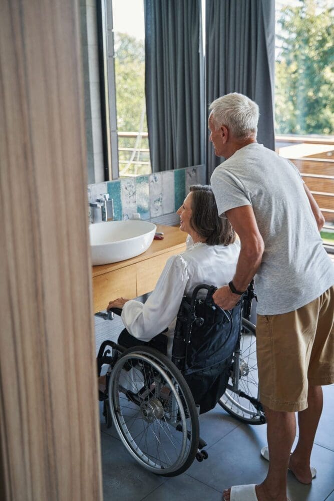 Elderly Man And Disabled Lady Looking In Mirror