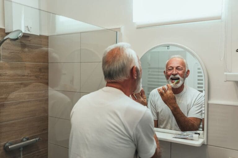 Elderly Man Smiling Brushing His Teeth